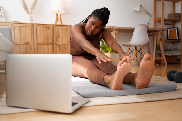 Full shot woman training with laptop