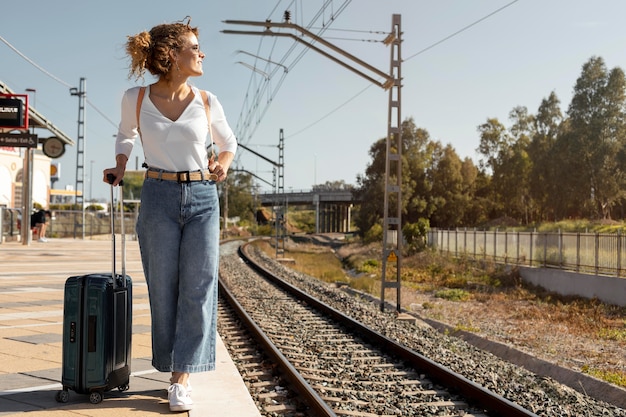 写真 手荷物を持って旅行するフルショットの女性