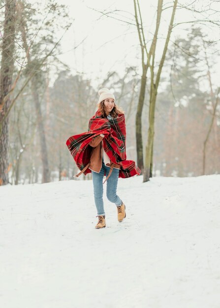 Donna piena del colpo che cammina nella neve