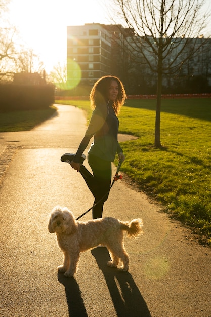 Foto donna del colpo pieno con il cane sveglio all'aperto