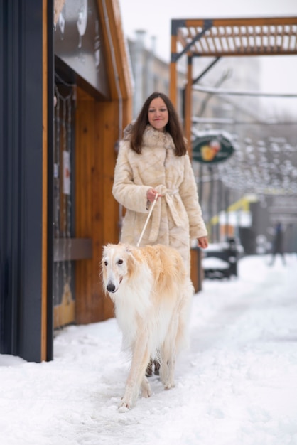 Full shot woman with cute greyhound dog