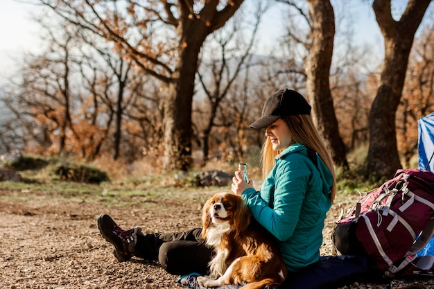 写真 屋外で犬とフルショットの女性