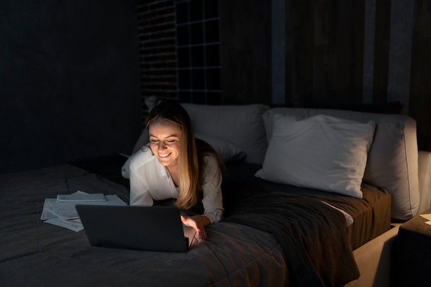 写真 夜遅くまで働くフルショットの女性