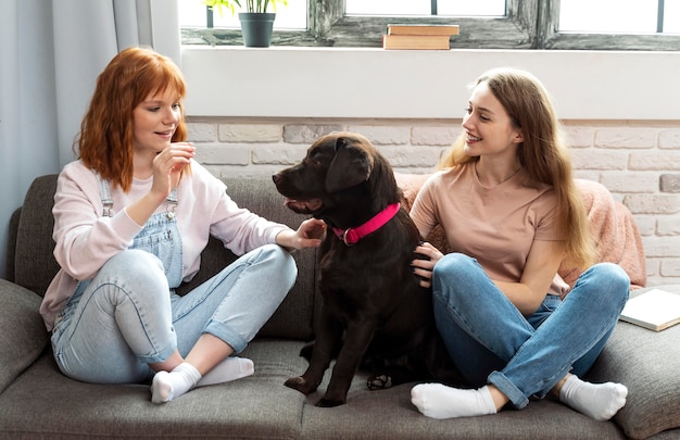 フルショットの女性とソファの上の犬