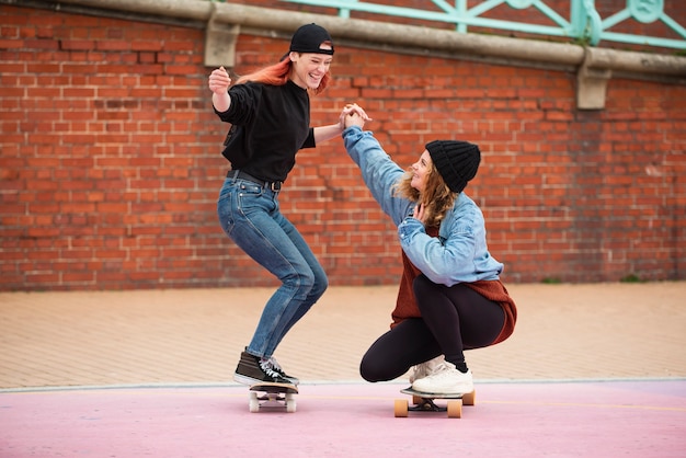 Foto donne a tutto campo che si divertono con gli skateboard