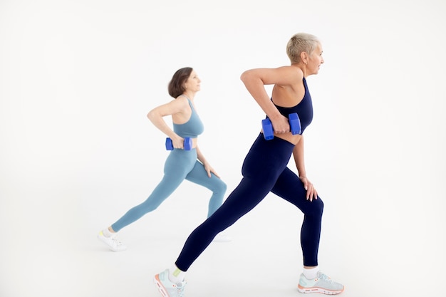 Full shot women holding dumbbells