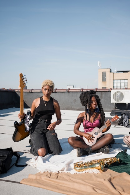 Foto donne a tutto campo che tengono in mano strumenti musicali