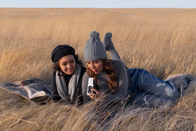 Full shot women laying on blanket outdoors