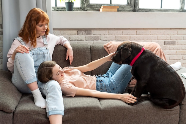 Full shot women laying on couch with dog