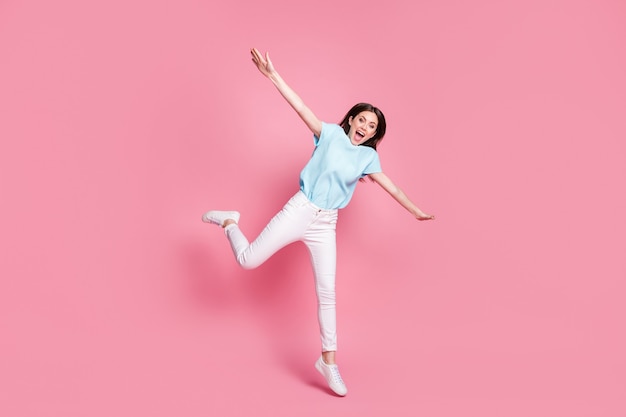 Full size photo of cheerful girl jump hold hands fly bird concept isolated over pastel color background