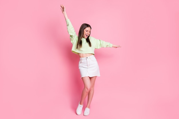 Full size photo of crazy candid funny funky girl enjoy dancing discotheque raise hands scream wear good look pullover isolated over pastel color background