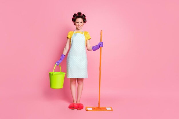 Full size photo of positive girl wife hold mop bucket wear dotted dress slippers isolated on