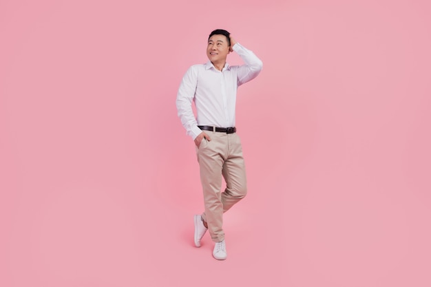 Full size photo of young asian man hand touch hair barber shop conditioner shampoo isolated over pink color background