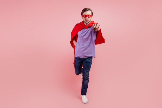 Full size photo of young superman strong power wear coat mask run fast isolated over pink color background