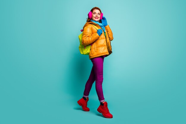 Full size portret van vrolijke dromerige vrouw gaan wandelen winterlezingen houden tas dragen geel roze paars rood groen trui outfit.