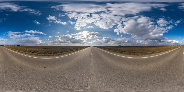 Full spherical seamless panorama 360 degrees angle view on no traffic asphalt road among fields in spring day with cloudy sky 360 panorama in equirectangular projection VR AR content