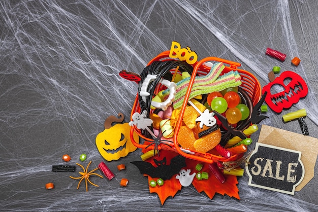 Foto pieno di caramelle concetto di vendita di cesto divertente sfondo di halloween spaventosa ragnatela tradizionale autunno zucche pipistrelli e ragni dessert festivo stile autunno classico vista dall'alto