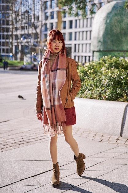 Full view of a Chinese woman walking in style through the city