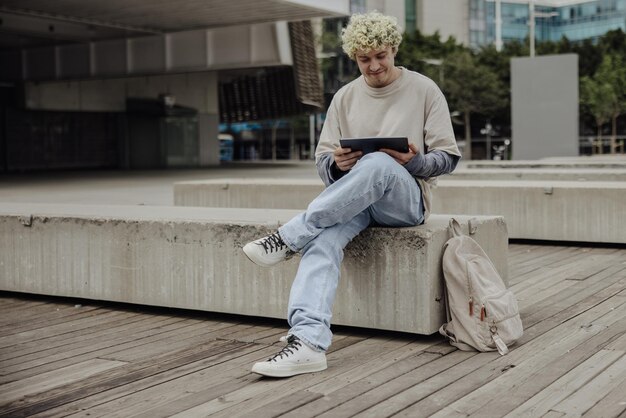 Full view of man in white tshirt with tablet