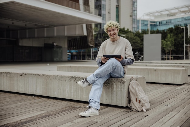 タブレットと白いTシャツの笑顔の男の全景