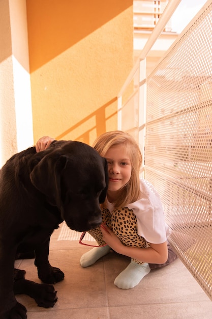 Photo full view of sweetie young girl hugs with her dog