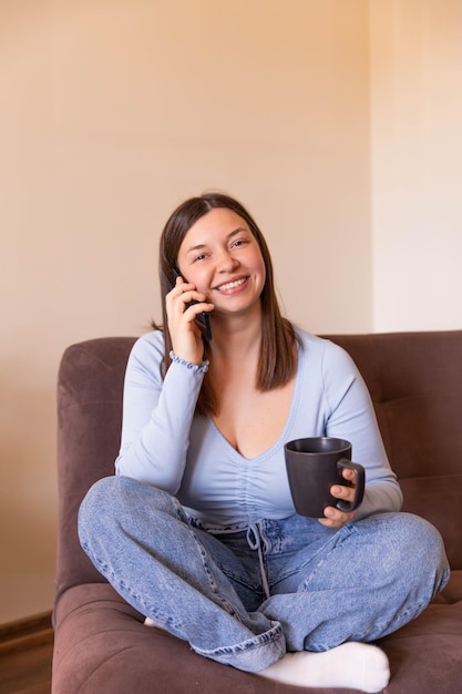 Full view of woman sitting at home talk on phone