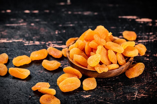 Full wooden plate with dried apricots