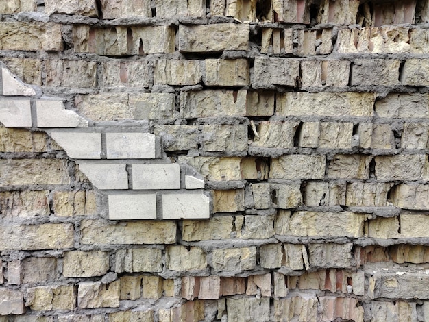 마주보는 세라믹 타일의 잔재와 금이 간 바닥이 있는 풀프레임 벽돌 벽