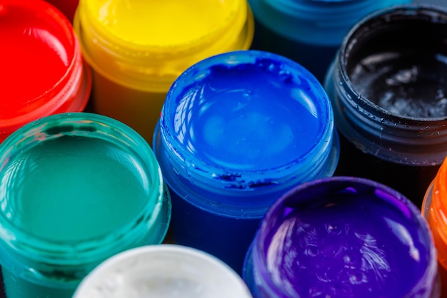 Fullframe closeup background of opened small gouache paint jars