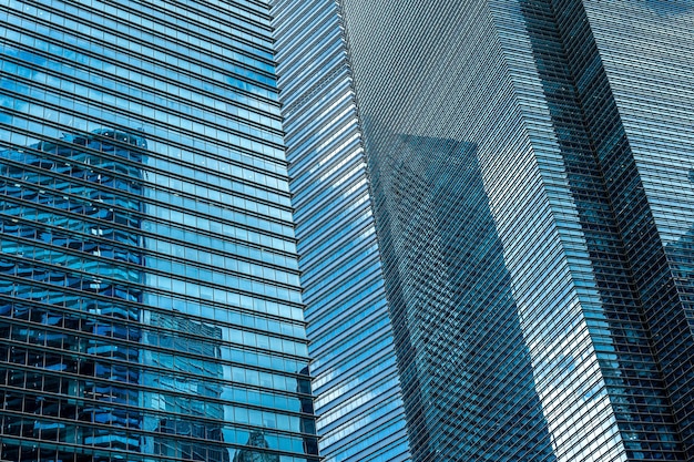 Fullframe shot of modern glass and metal skyscraper facade in cool blue tones background for financial services and business concepts featuring sleek and contemporary architectural design