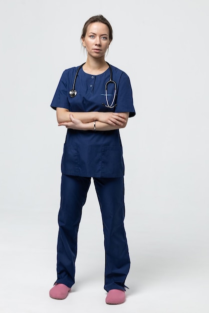 A fulllength doctor on a white background Professional medical care in the clinic A young woman looks at the camera
