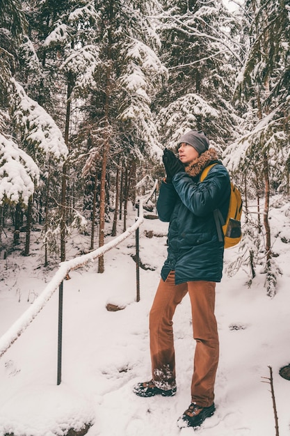 Foto a figura intera dell'uomo nella foresta invernale