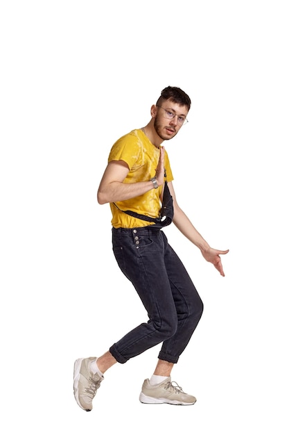 Fulllength portrait of a funny guy dancing in studio isolated on white background