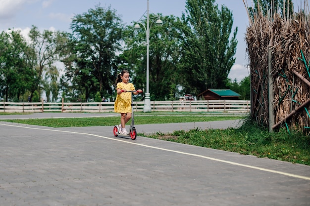 Fulllength portrait of a girl on a scooter healthy pastime  family sports activity