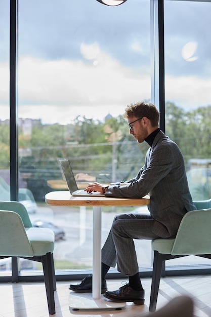 Fulllength portrait of a successful programmer working on IT software in a modern office interior