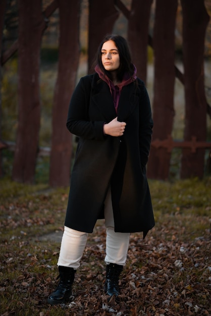 Photo fulllength portrait of a woman against the background of a wooden gate in autumn