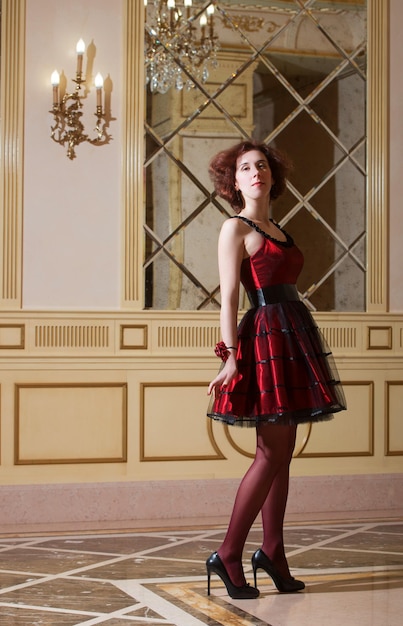 Fulllength portrait of a woman in red cocktail dress