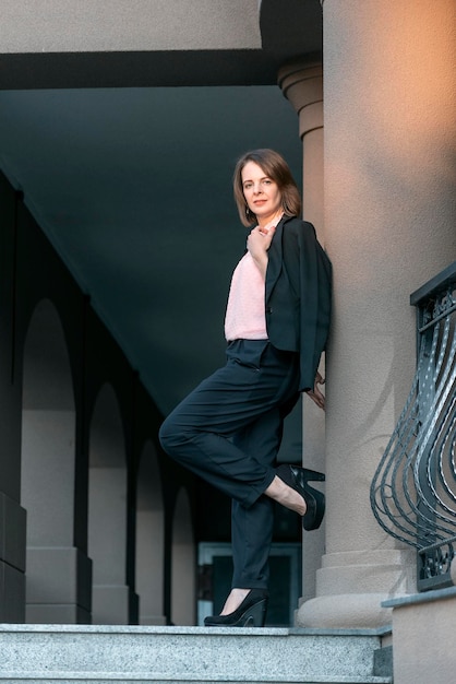 Fulllength portrait of young female director in business casual clothing Girl in pantsuit