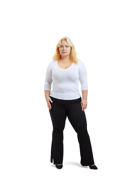 Fulllength portret van plussize vrouw, gekleed in witte t-shirt en jeans poseren geïsoleerd op witte studio