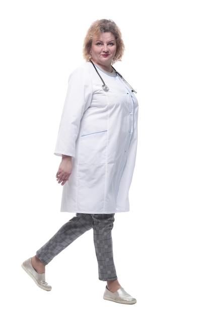 Fulllength senior female doctor confidently striding forward