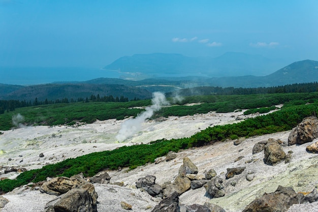 Fumarole field on the slope of Mendeleev volcano on Kunashir island overlooking the ocean in the haze