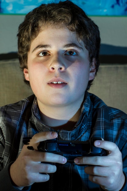 집에서 조이스틱으로 컴퓨터 게임을 하는 재미있는 소년.