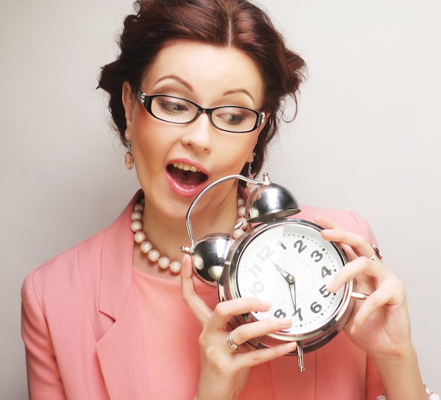 Fun businesswoman with alarmclock