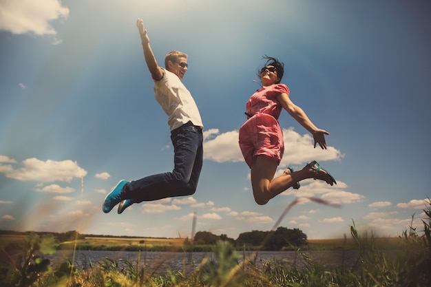 Fun couple in jump on the outdoor background