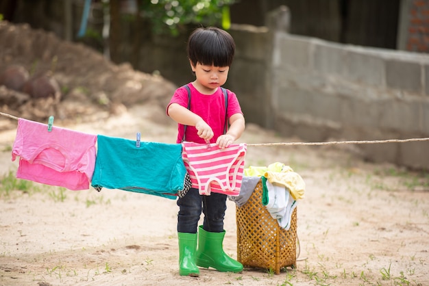 Foto divertimento bambino felice per lavare i vestiti e ride e in una soleggiata estate.