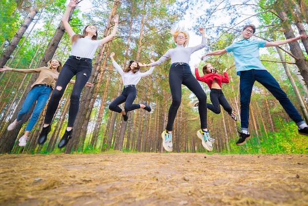 여름 숲에서 장난기 가득한 기분으로 즐겁게 점프하는 십대들