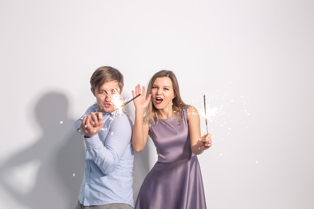 Fun love and holiday concept  man and woman fooling around with sparklers