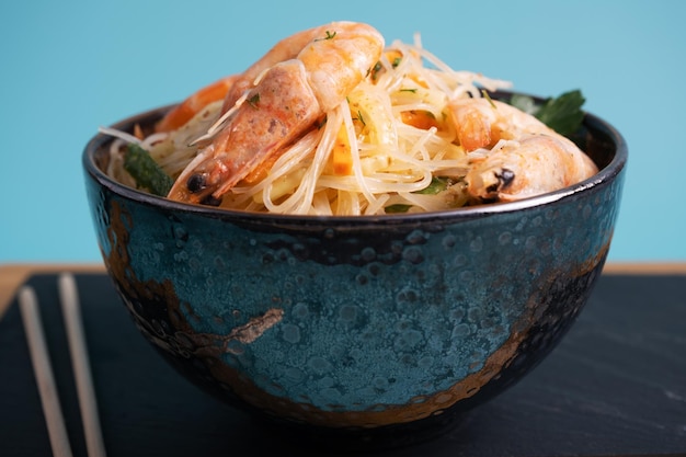 새우를 곁들인 펀초사 샐러드 파란색 배경에 아시아 요리 한 접시