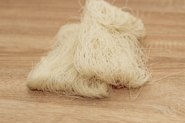 Funchoza rice glass noodles on a wooden board