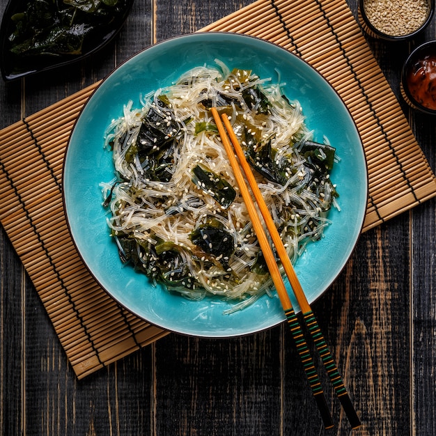 Funchoza salade met wakame op donker.